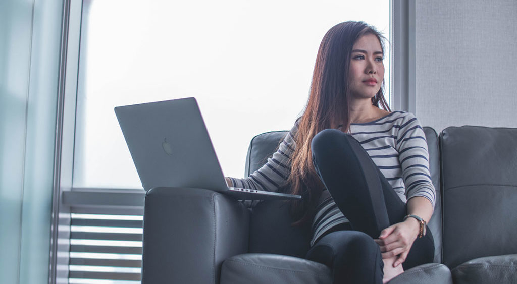 Seated woman with laptop dealing with job rejection